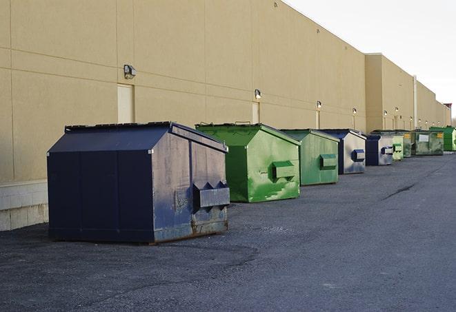 construction workers toss wood scraps into a dumpster in Ruidoso Downs, NM